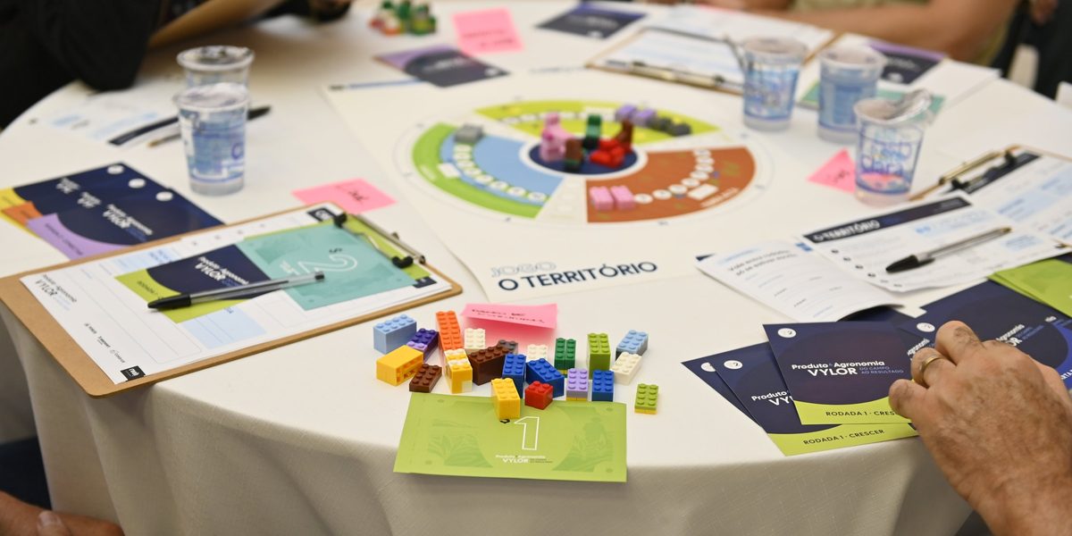 Mesa do team building da Vylor com o jogo O Território, cartões e peças de montar