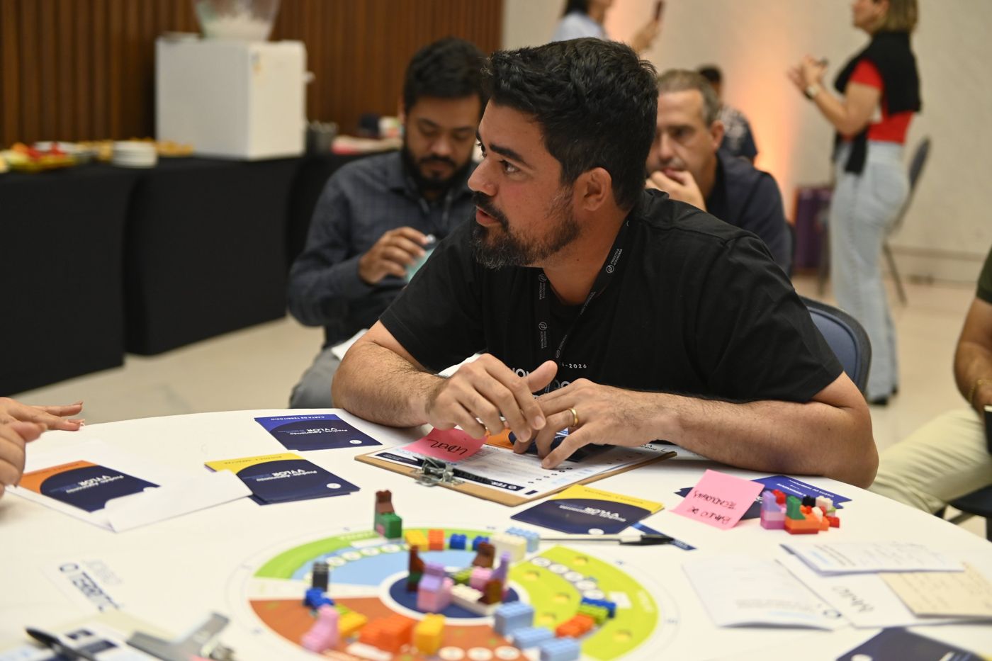 Participantes em uma dinâmica de tabuleiro durante workshop da Reali